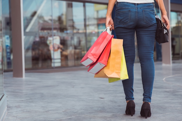 Woman carrying shopping bags while walking along the street