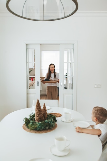 Woman carrying a tray with a breakfast at home