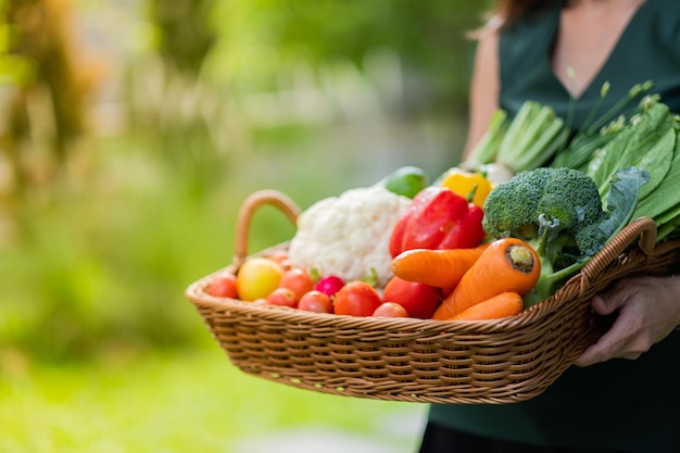 woman carrying vegetables basket with nature background