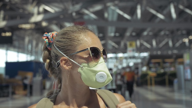 Woman caucasian at airport with wearing protective medical mask on head against the background of the plane Coronavirus sarscov2 covid19