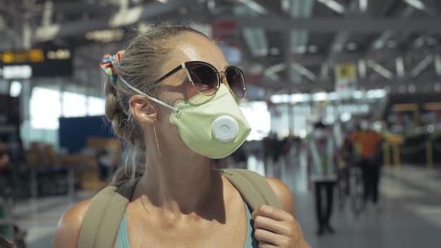 Woman caucasian at airport with wearing protective medical mask on head against the background of the plane Coronavirus sarscov2 covid19