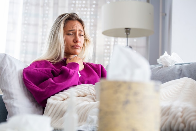 Woman Caught Cold and Flu Sneezing into Tissue.