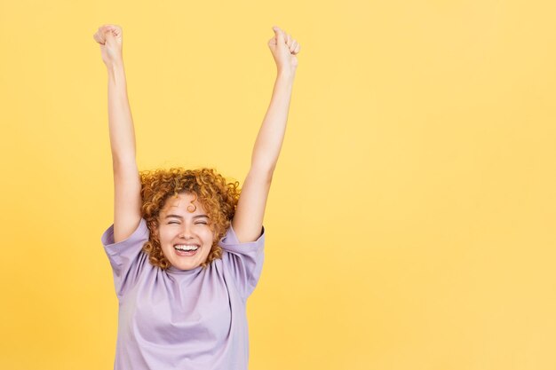 Photo woman celebrating while raising the arms and smiling