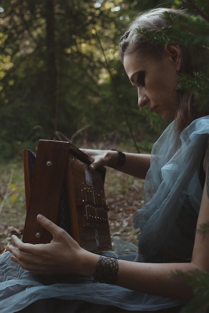 Woman in celtic style clothing holding wooden box scenic photography