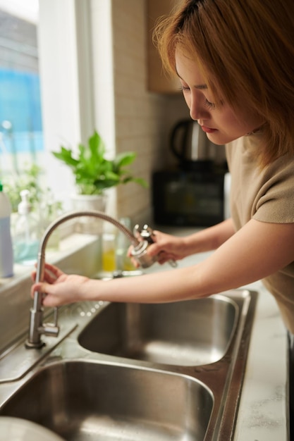 Woman Changing Leaking Sink Tap