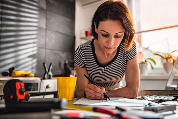 Woman checking kitchen blueprints