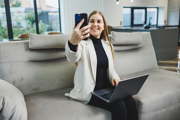 Woman cheerful charming person sitting behind a netbook watching having a good mood working at home indoors Remote freelance work