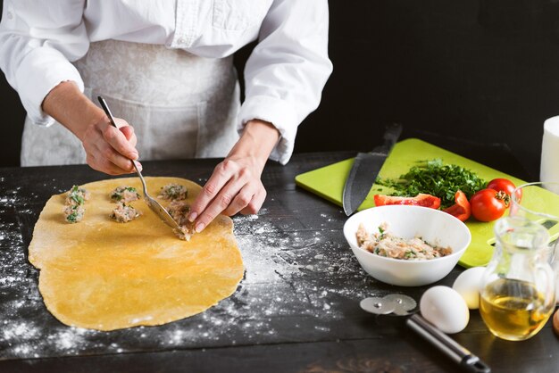 Woman chef cooks step by step the traditional ravioli