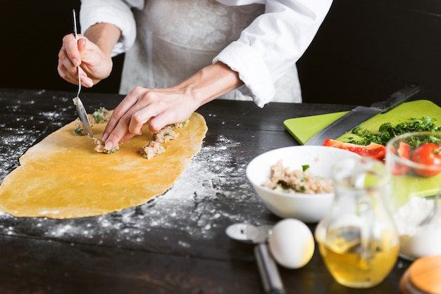 Woman chef cooks step by step the traditional ravioli