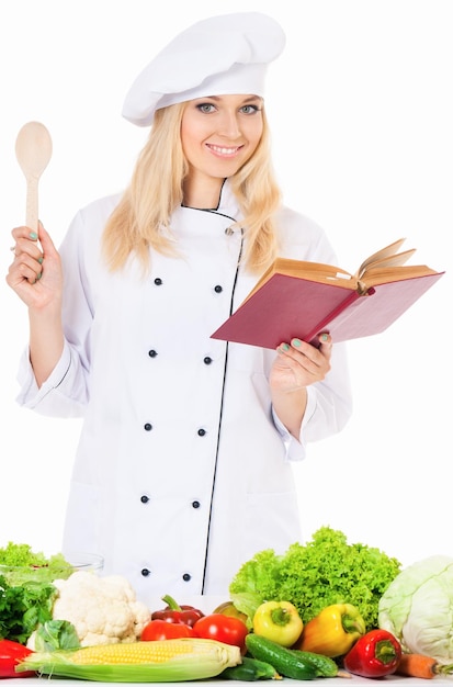 Woman in chef hat with fresh vegetables isolated on white background