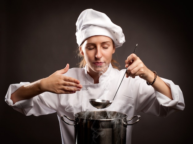 woman chef holding a ladle and smelling