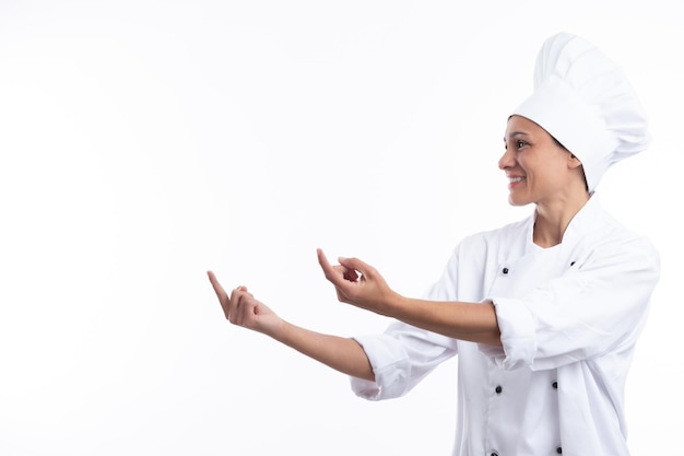 Woman chef pointing with fingers isolated on white background with copy space