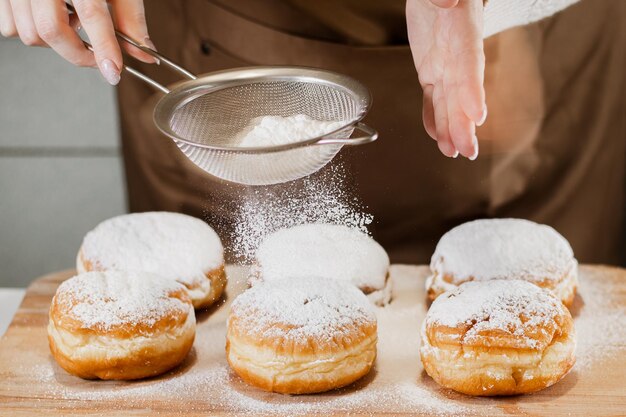 Photo woman chef prepares fresh donuts in her bakery cooking traditional jewish hanukkah sufganiyot small business concept