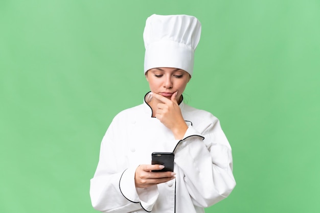 A woman in a chef's hat is using a phone