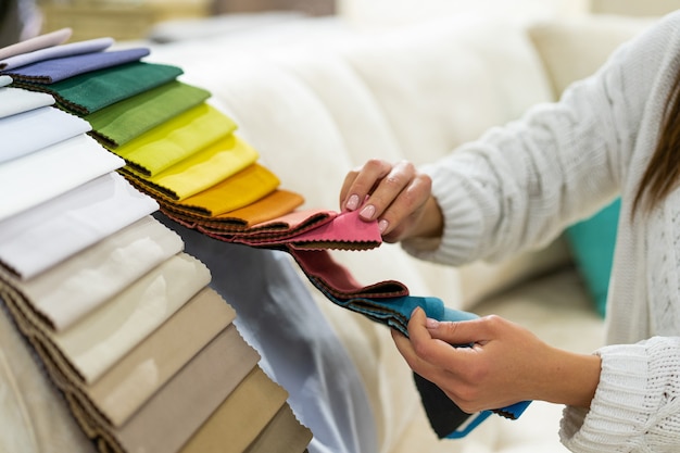 The woman chooses the fabric on the sofa