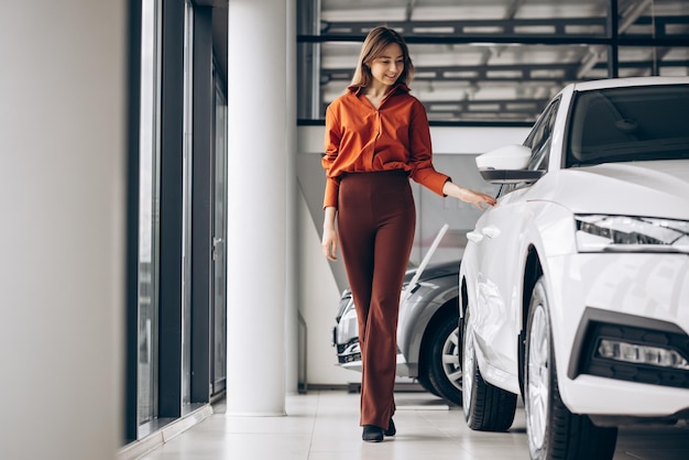 Woman choosing a car in a car showroom