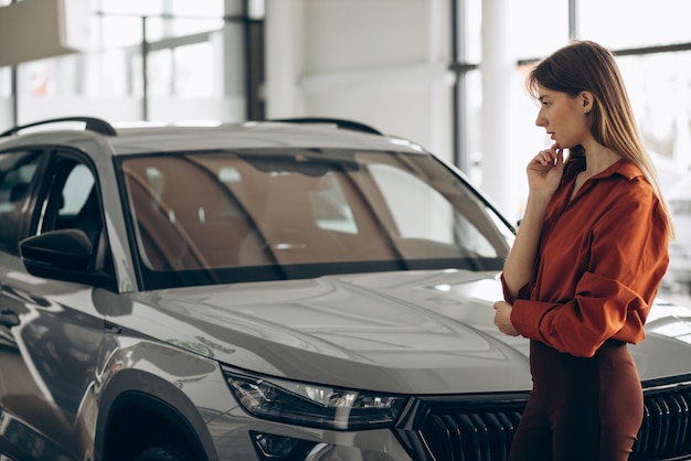 Woman choosing a car in a car showroom