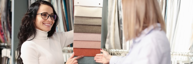 Woman choosing color of fabric from many samples in store combination of colors in interior of