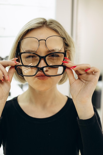 Woman choosing a pair of eyeglasses at optics store