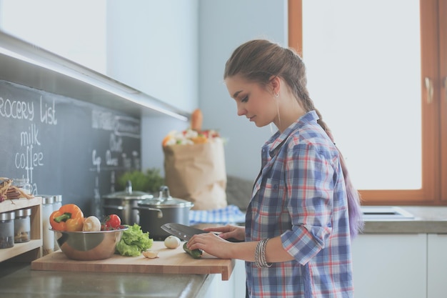 A woman chopping vegetables in a kitchen