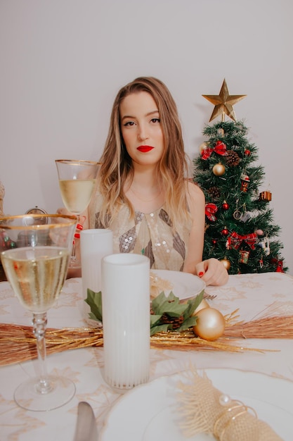 Woman at christmas dinner with sparkling wine and gifts