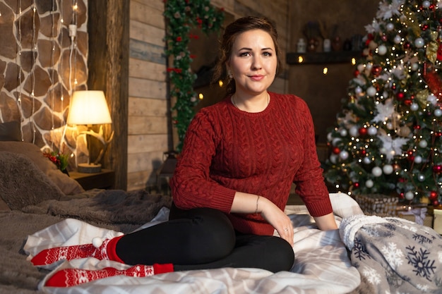 Woman on christmas eve in bad at home in new year interior