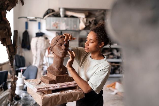 Woman clay sculpting side view