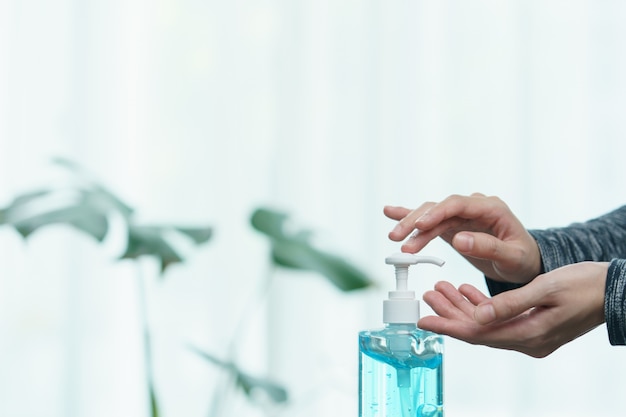 Woman cleaning her hands with sanitizer liquid antibacterial gel,  in quarantine, corona virus concept.