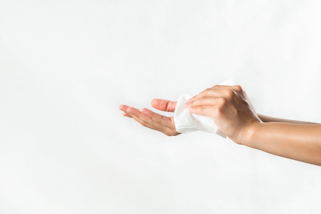 Woman cleaning her hands with white soft tissue paper. isolated on a white