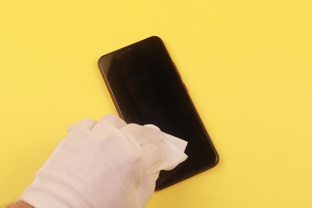 Woman cleaning mobile phone with antiseptic wipe