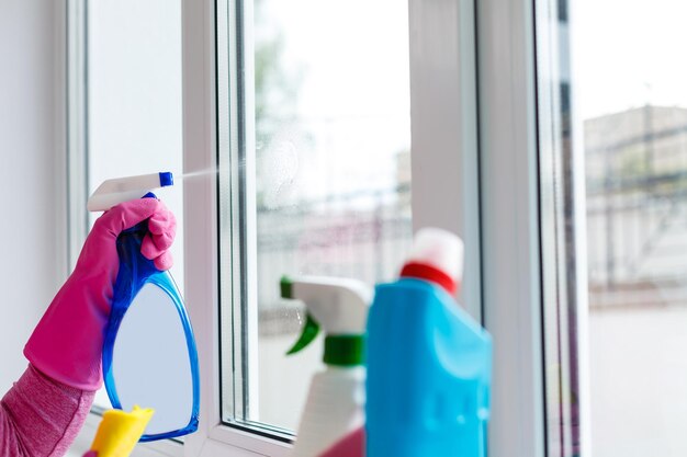 Woman cleaning a window with cleaning sprayer.