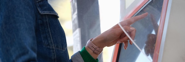 Woman clicks on screen on terminal person uses electronic bulletin board in public place