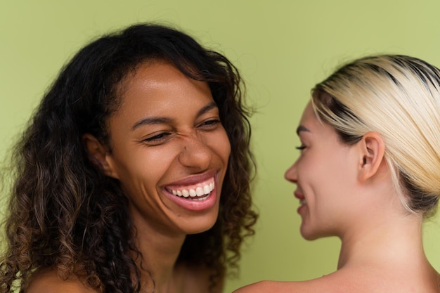 Woman close beauty portrait mixed race black skin and white skin two female on green background