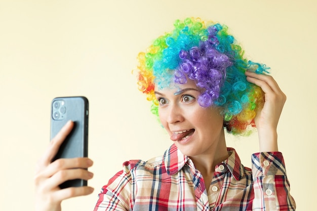 Woman in clown color wig taking selfie, funny fools day