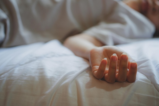 Woman committing suicide in bed focus on the hand of dead body The concept of die alone