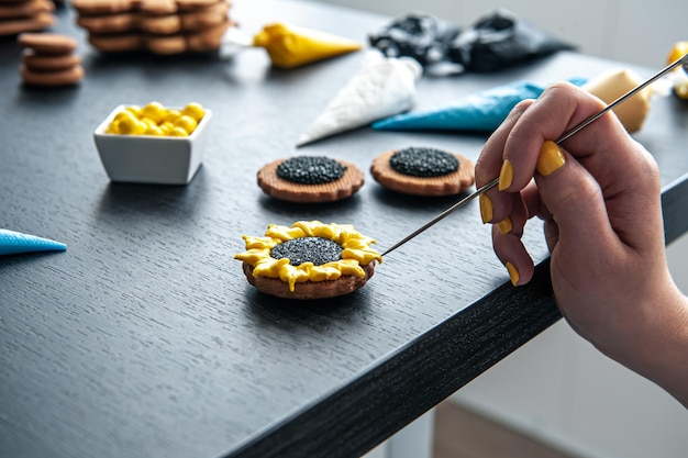 Woman confectioner making gingerbread sunflower gingerbread design