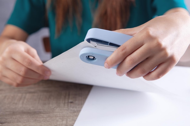 Woman connects papers with a stapler