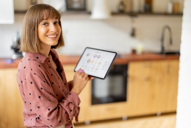 Woman controls home devices with a digital tablet at home