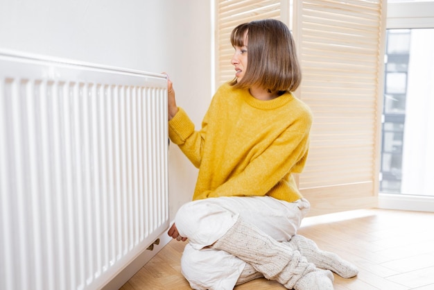 Woman controls room temperature with a thermostat