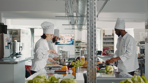 Woman cook preparing organic bell pepper in frying pan, doing authentic gourmet dish on stove. Professional chef cooking fresh meal and culinary food recipe with vegetables and meat.