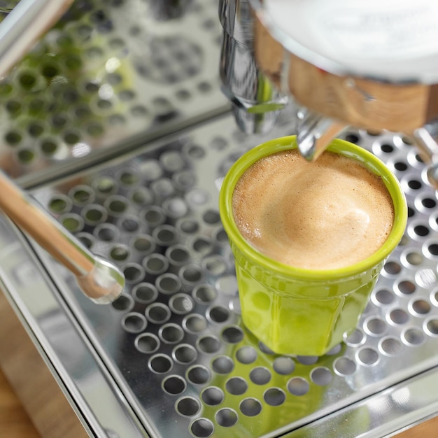 Woman cooking espresso with machine