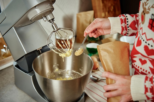 Woman cooking at home kitchen use electric mixer to preparing dough