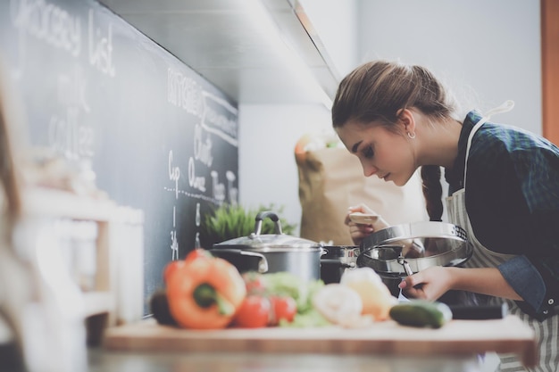 A woman cooking in a kitchen with a chalkboard that says'food'on it