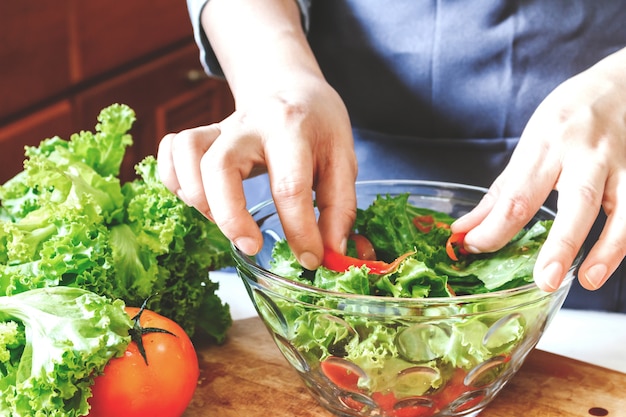 Woman cooking mixing salad