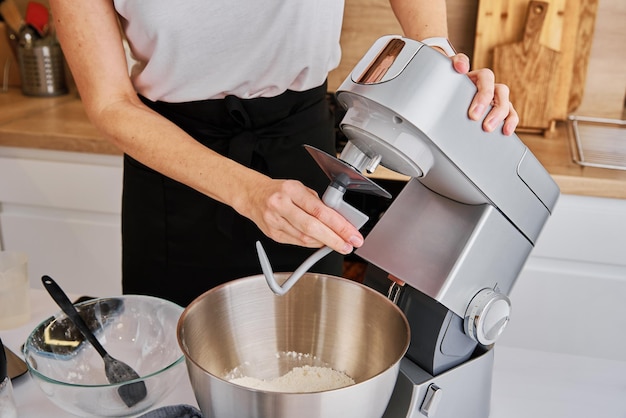 Woman cooking at preparing food using food processor