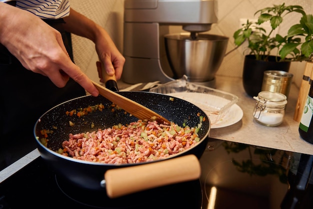 Woman cooking sauce bolognese in kitchen