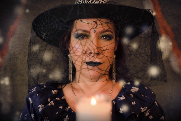 Woman costumed as a witch holding lighted candle