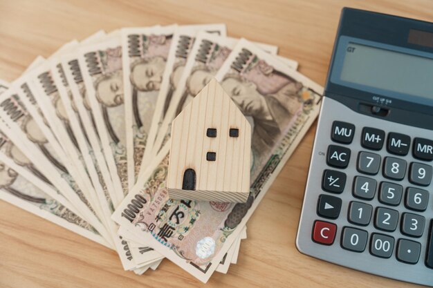 Woman counting Japanese Yen banknote with House model Real Estate Home Mortgage Japan cash Tax Recession Economy Inflation Investment finance and savings concepts