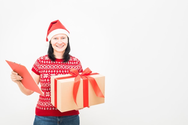 Woman courier in santa hat and christmas sweater holding gift