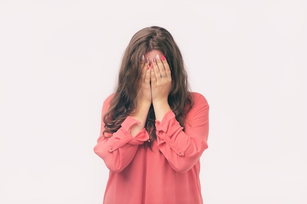 A woman covered her face with her hands crying She is offended on her boyfriend